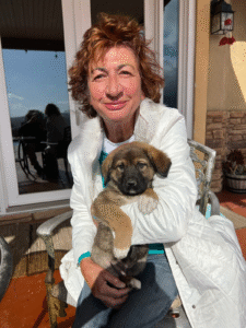 Great Pyraneese Puppy with his Mom holding him.